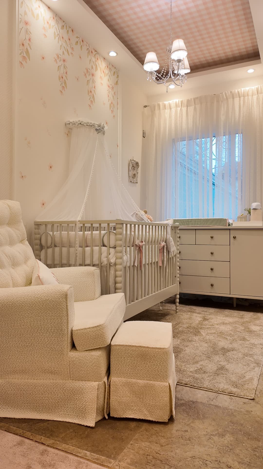 Quarto de bebê em tons neutros com poltrona acolchoada e berço cinza